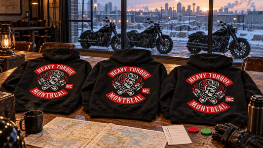 Three Heavy Torque Montreal motorcycle club hoodies laid back-side-up on a Calgary clubhouse table during a snow go-or-no-go review
