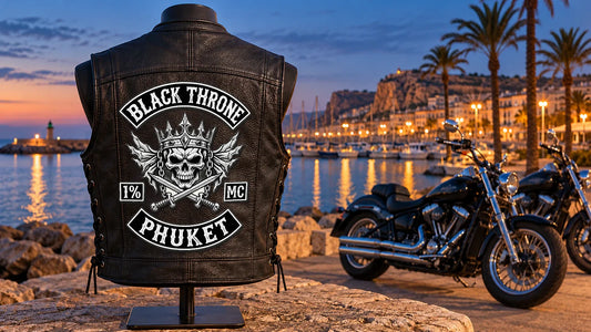 Black Throne Phuket motorcycle club back patch integrated into the central back panel of a black leather vest at a Costa Blanca harbor.