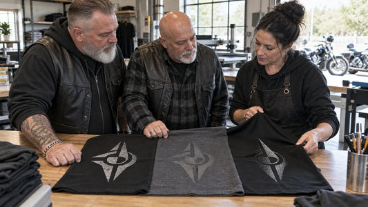 Motorcycle club buyers compare decoration samples on the actual shirt fabrics at a print workshop counter.