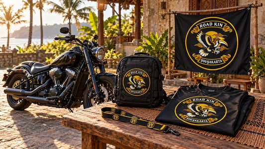 Road Kin Yogyakarta motorcycle club festival-preparation table with logo gear and an unbranded V-twin cruiser in a tropical courtyard.
