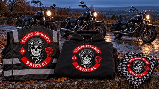 Redline Outriders Bristol motorcycle club night-ride briefing gear beside unbranded V-twin cruisers at a British autumn lay-by.