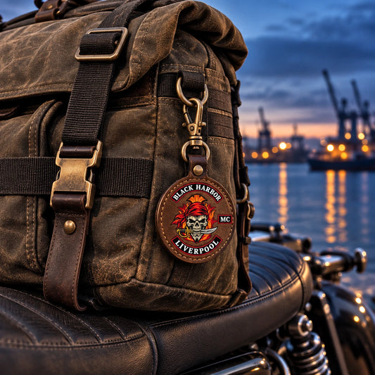 Custom motorcycle club carabiner keychain attached to a rugged riding bag with an authorized logo.