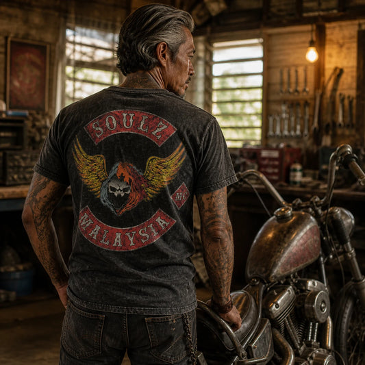 SOULZ MC Malaysia member wearing a distressed charcoal vintage-washed motorcycle club T-shirt beside an old V-twin chopper.