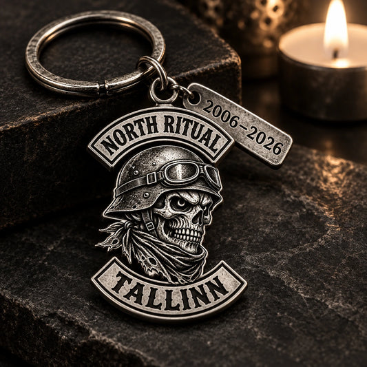 Antique metal motorcycle club anniversary keychain with a monochrome authorized emblem and engraved memorial date.