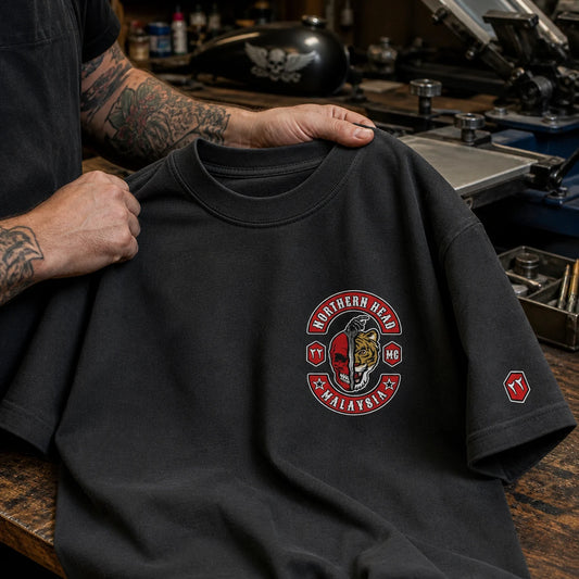Northern Head MG charcoal 207 GSM heavyweight club T-shirt being inspected for its dense cotton, reinforced shoulder seam and substantial collar.