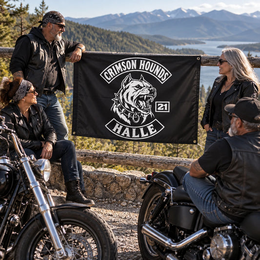 Mature American V-twin riders hold a custom motorcycle club triangle flag at a desert service station.