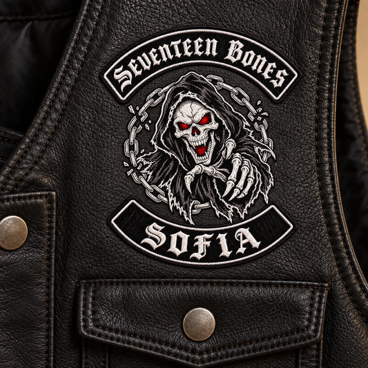 Compact embroidered club identity chest patch positioned above the pocket for a motorcycle club, shown at black leather vest front panel.
