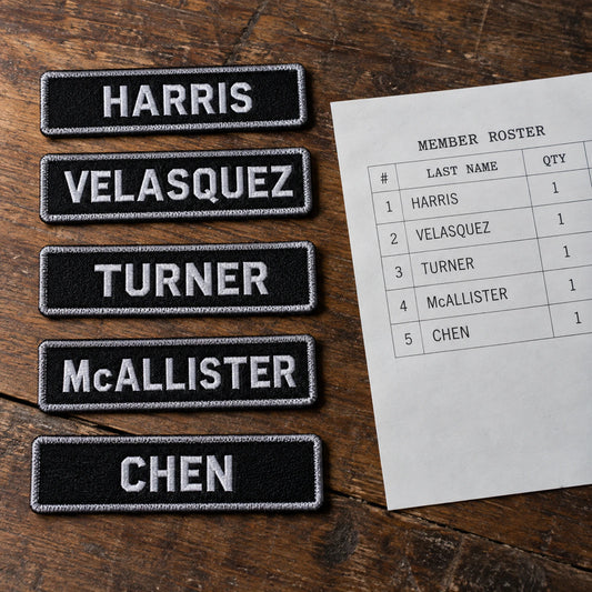Finished name-bar samples aligned beside a neatly printed member roster for spelling and quantity confirmation, showing custom motorcycle club name bar patch options.