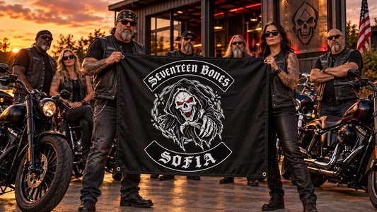 Proud motorcycle club riders posing with their finished custom event banner at sunset.