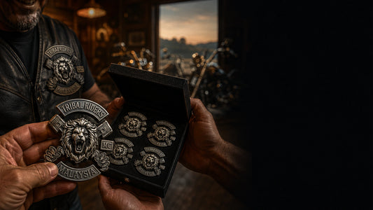 Identical one-piece antique silver TRIBAL RIDERS lion pins presented to a motorcycle club member in a warm clubhouse.