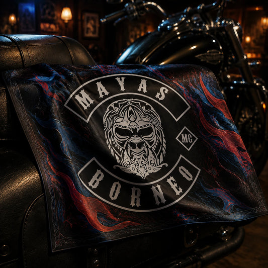 Lightweight full-color polyester motorcycle club bandana with the authorized MAYAS BORNEO MC logo, draped over a black leather touring motorcycle saddle in a premium clubhouse.