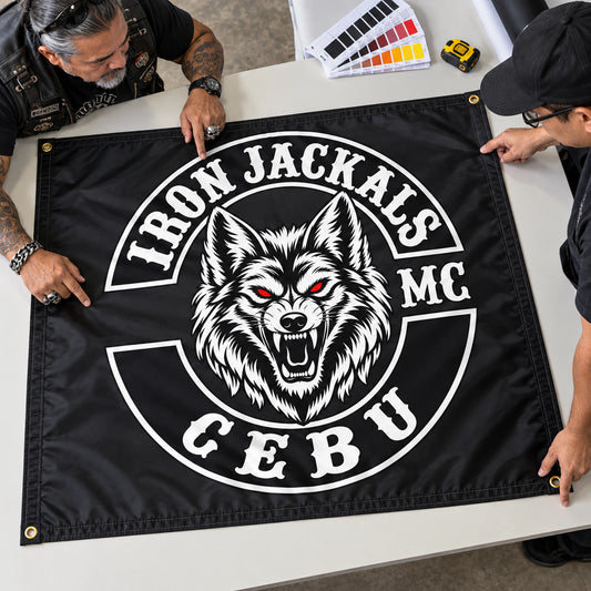 A motorcycle club president and designer review a full-size custom flag proof before production.