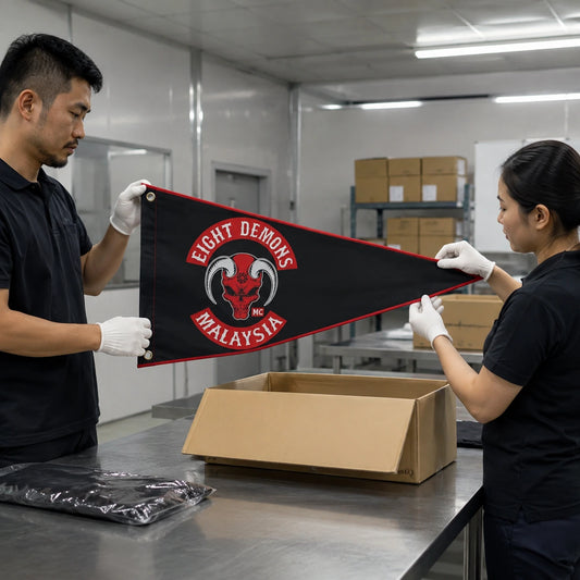 A custom motorcycle club triangle flag passes final inspection before being boxed for delivery.