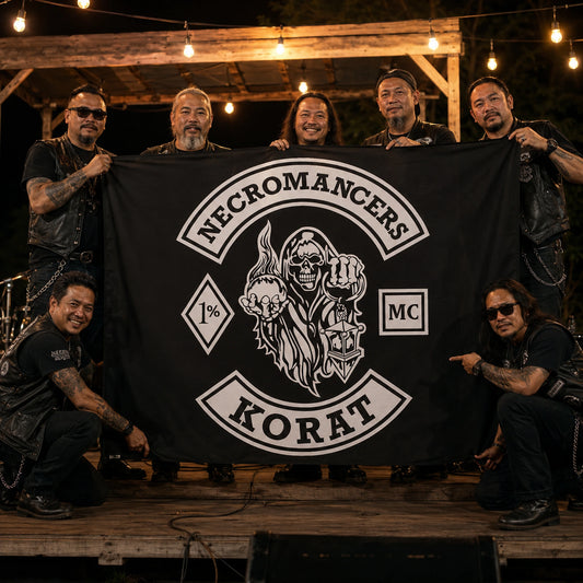 Motorcycle club members present a custom emblem flag on a warmly lit anniversary rally stage.