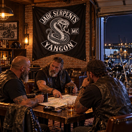 Mature motorcycle club riders planning a route beneath a custom swallowtail flag in their clubhouse.
