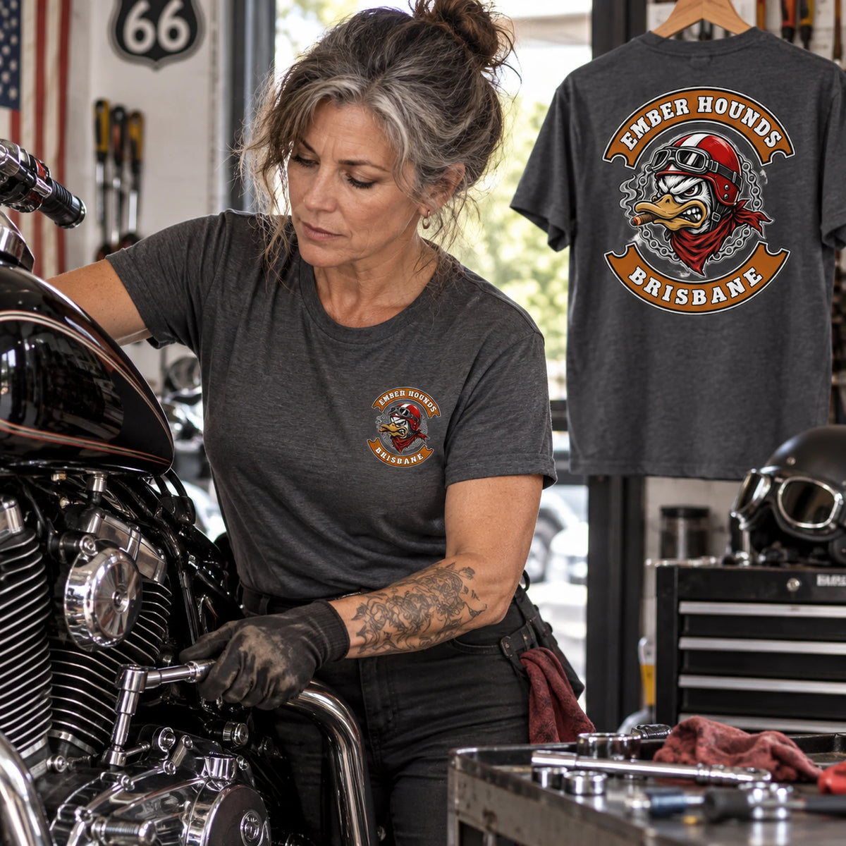 Ember Hounds mechanic wearing a charcoal grey club T-shirt in a V-twin garage.