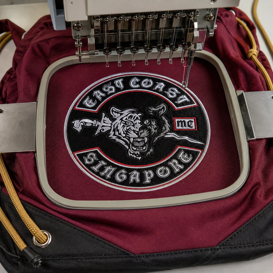 A raised motorcycle club emblem is embroidered onto a premium drawstring bag.