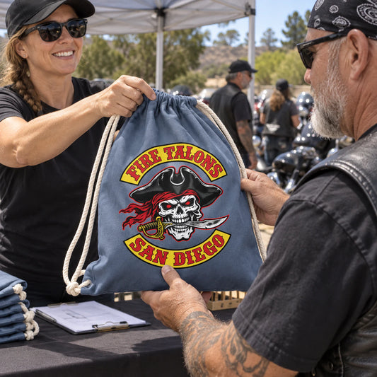 Motorcycle club riders receive custom participant drawstring bags at a community charity ride.