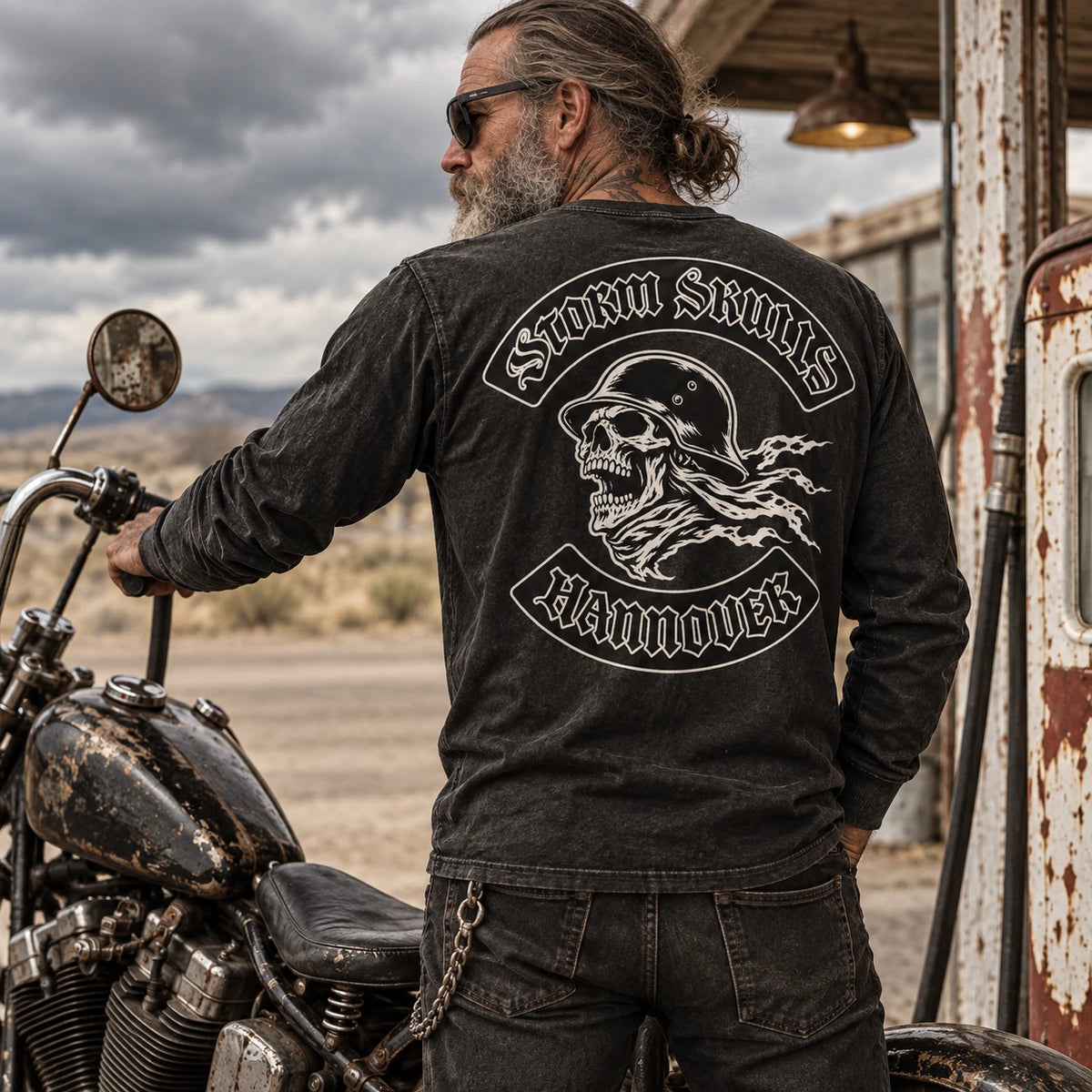 Faded black motorcycle club long-sleeve shirt beside a vintage custom motorcycle.