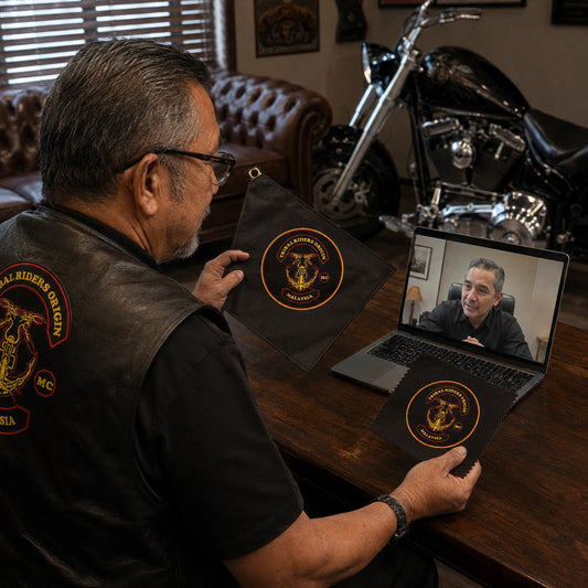 A motorcycle club chapter representative receives remote design assistance while reviewing a custom diamond flag proof and material sample.