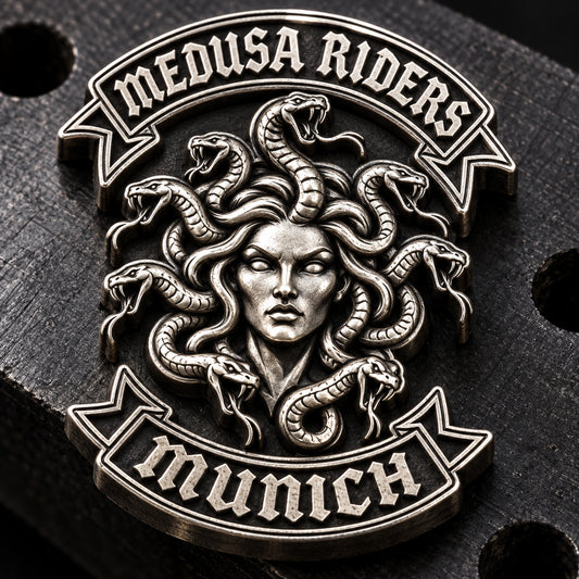 Fully sculpted antique silver MEDUSA RIDERS pin with rounded face and snake relief on a machinist block.