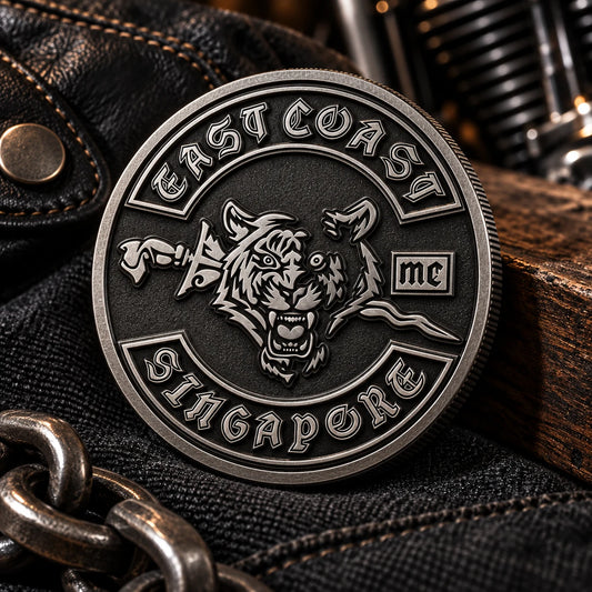 Gunmetal motorcycle club challenge coin on charcoal fabric.