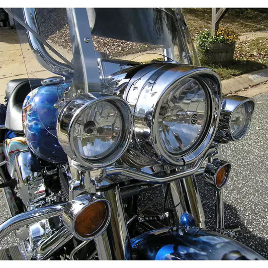 Chrome motorcycle light visors installed on a Harley-Davidson front lighting assembly