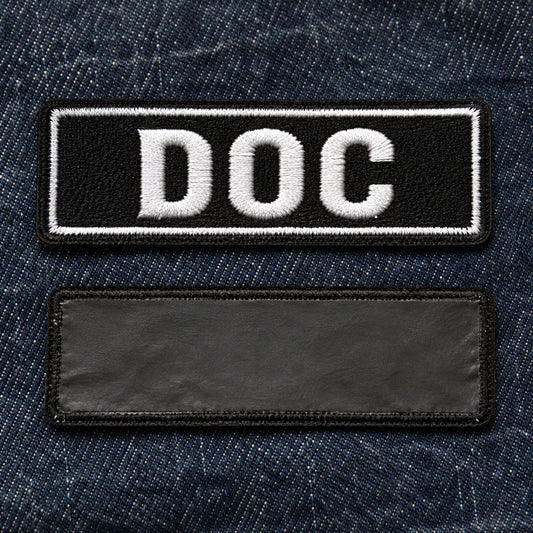 Front and back views of an iron-on name bar, clearly showing the smooth heat-seal adhesive backing on dark denim fabric, showing custom motorcycle club name bar patch options.