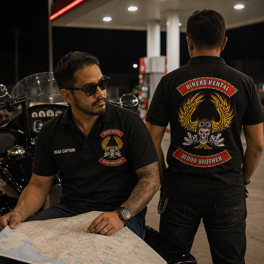 Two Bikers Kental members at a night fuel station wear black polos with a ROAD CAPTAIN title, chest emblem, and large back logo.