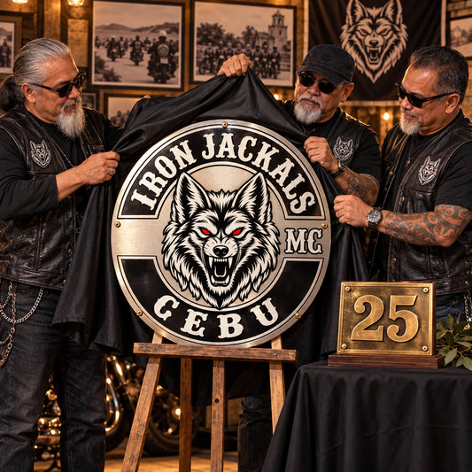 Senior motorcycle club members unveiling a custom commemorative metal sign at a chapter anniversary.