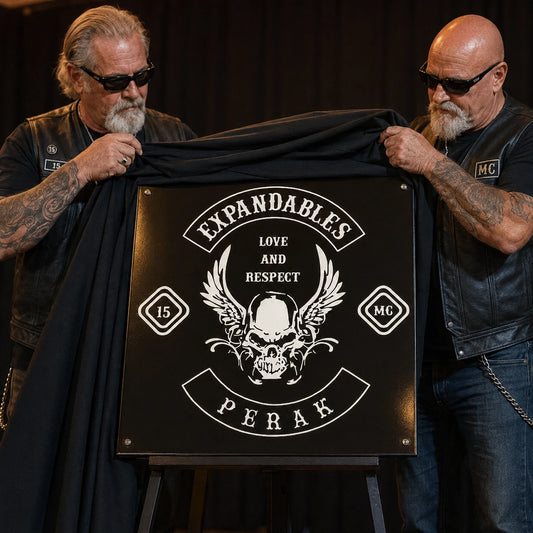 Chapter officers unveiling a commemorative motorcycle club anniversary metal sign.