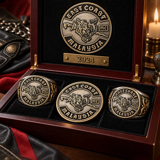 Custom motorcycle club anniversary rings and medallions arranged for a milestone presentation.