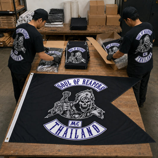 Bulk custom motorcycle club swallowtail flags being inspected, folded and packed for worldwide shipping.