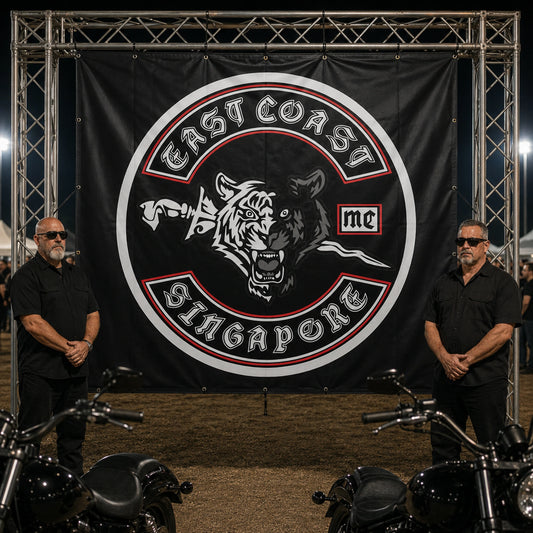 A large custom motorcycle club banner creating a strong entrance at a crowded rally.