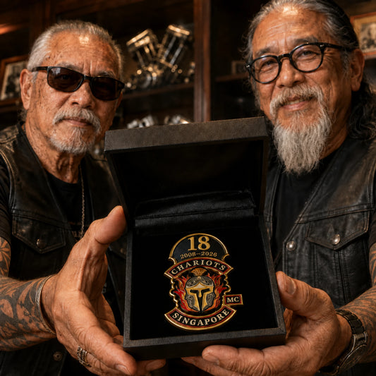 Veteran motorcycle club founders holding an 18th anniversary pin with their official club logo.