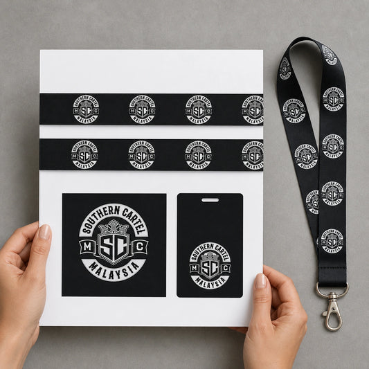 Hands reviewing a motorcycle club lanyard artwork proof beside the matching physical sample.
