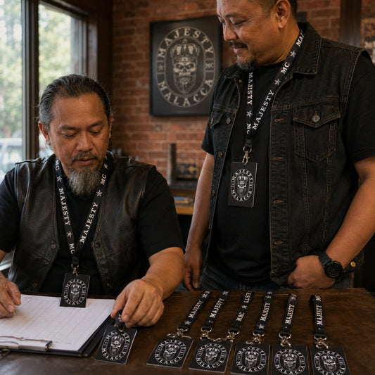 Motorcycle club members reviewing matching lanyards and member credentials at a clubhouse desk.