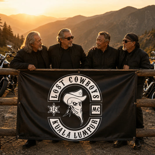 Older motorcycle club riders gathered around a commemorative custom banner at a mountain turnout.