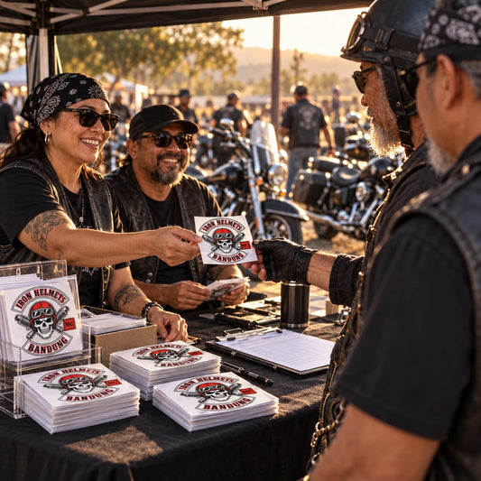 Motorcycle rally volunteers handing custom club sticker packs to arriving V-twin riders at event check-in.