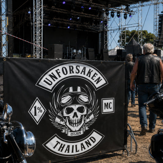 A custom motorcycle club banner displayed at a large open-air rider gathering.
