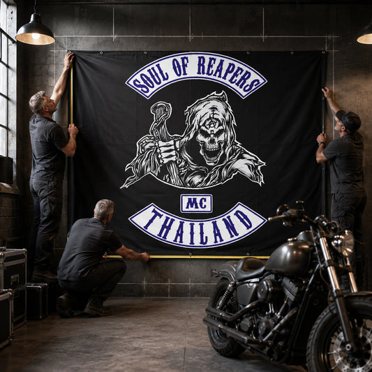 A setup crew measuring and positioning an extra-wide custom motorcycle club banner.