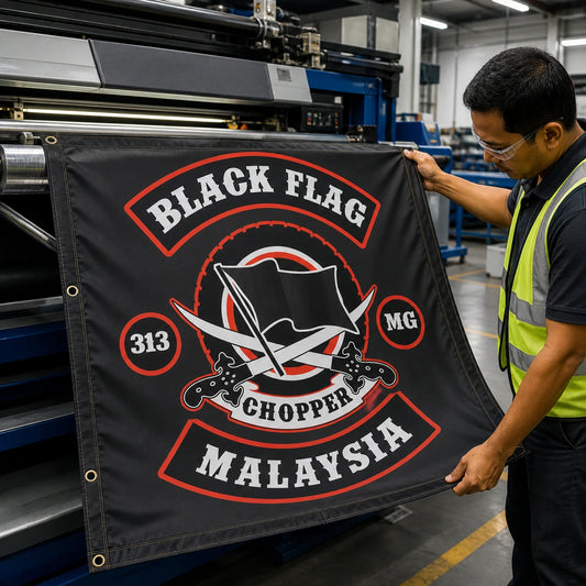Print technician checking the detailed artwork, stitched hem and grommets on a custom motorcycle club square flag.