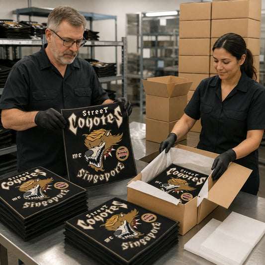 Fulfillment staff inspect and pack finished custom motorcycle club square flags for shipping.