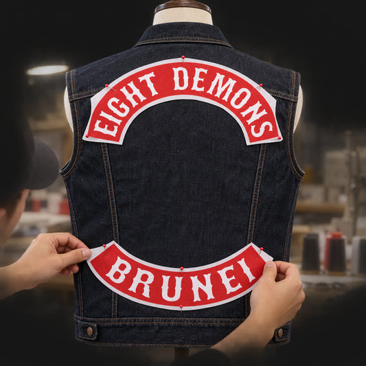 Motorcycle club product: Designer positioning custom top and bottom rocker layouts on a complete vest.