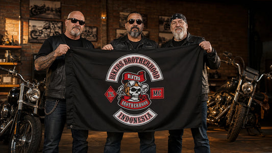 Motorcycle club riders displaying a finished custom exchange flag inside a brick clubhouse garage.