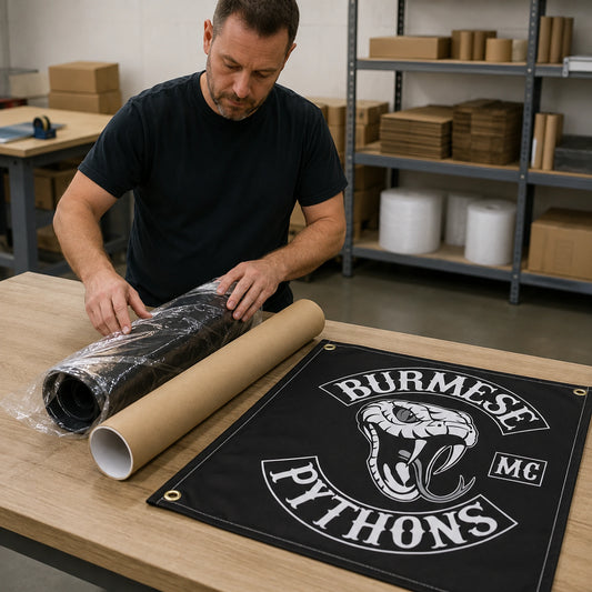 A finished custom motorcycle club banner being checked and packed for worldwide shipping.