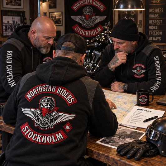 Motorcycle club officers wearing coordinated chapter hoodies with role titles during a clubhouse route meeting.