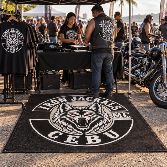 A custom motorcycle club rug defines a rally merchandise and registration booth.