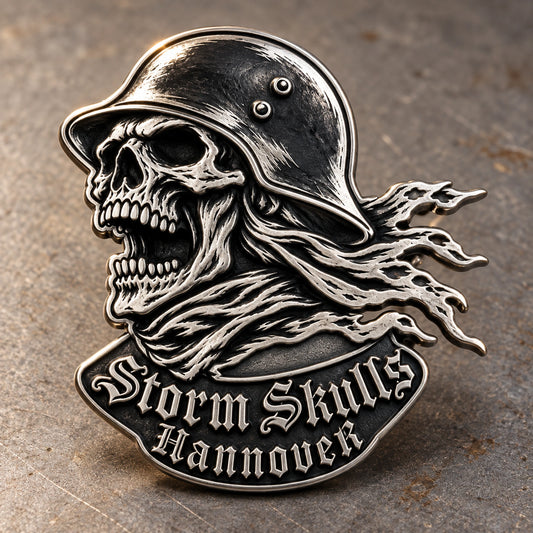 Helmeted STORM SKULLS antique silver pin with a complete skull-profile silhouette and deep relief on a workshop surface.