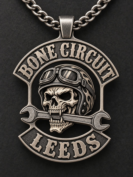 A structurally unified Bone Circuit Leeds motorcycle club pendant with a complete chain and restrained satin matte silver finish.